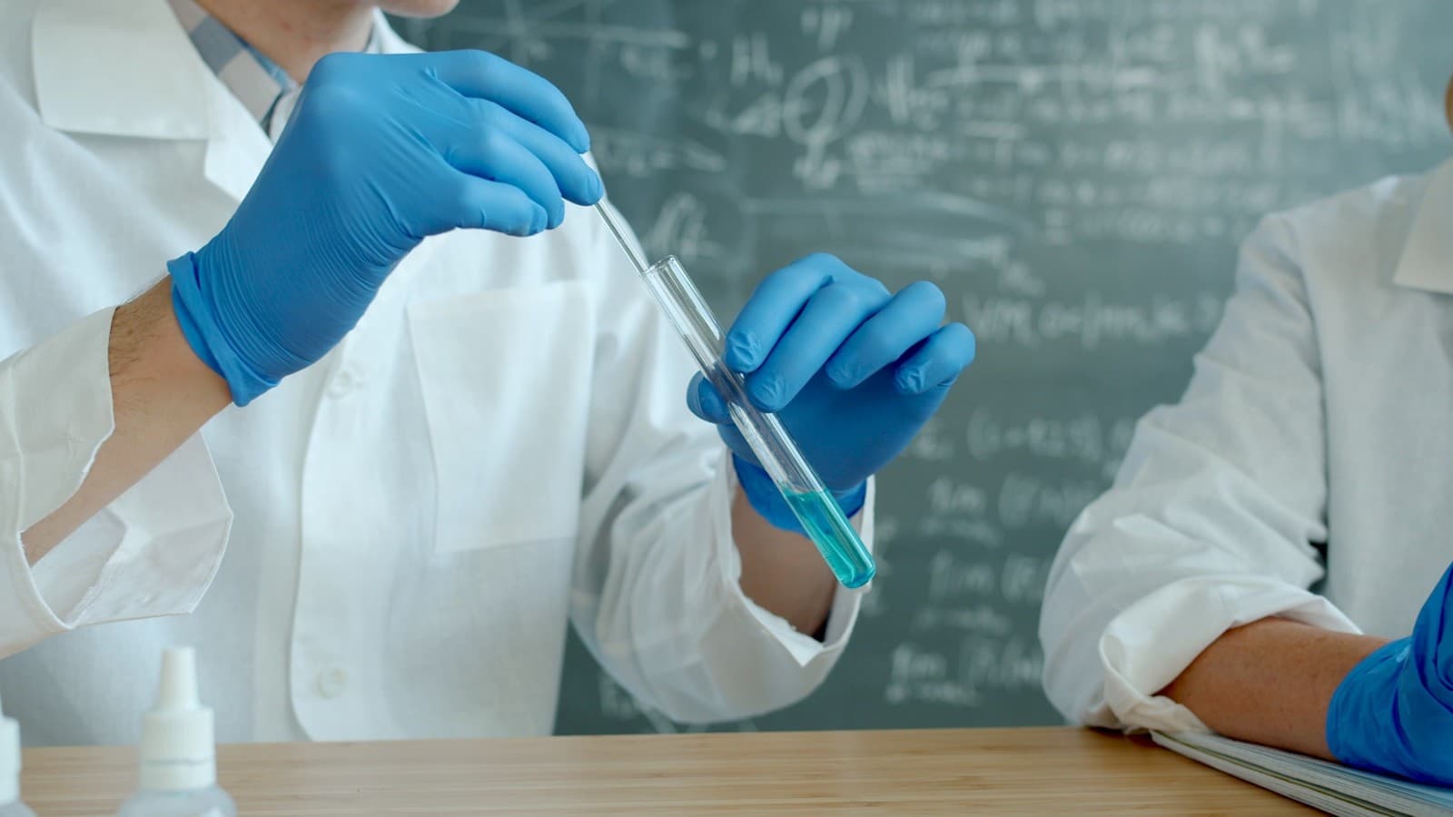 Scientifiques en blouse blanche manipulant des tubes à essai — analyses lab et traçabilité CBD Moody