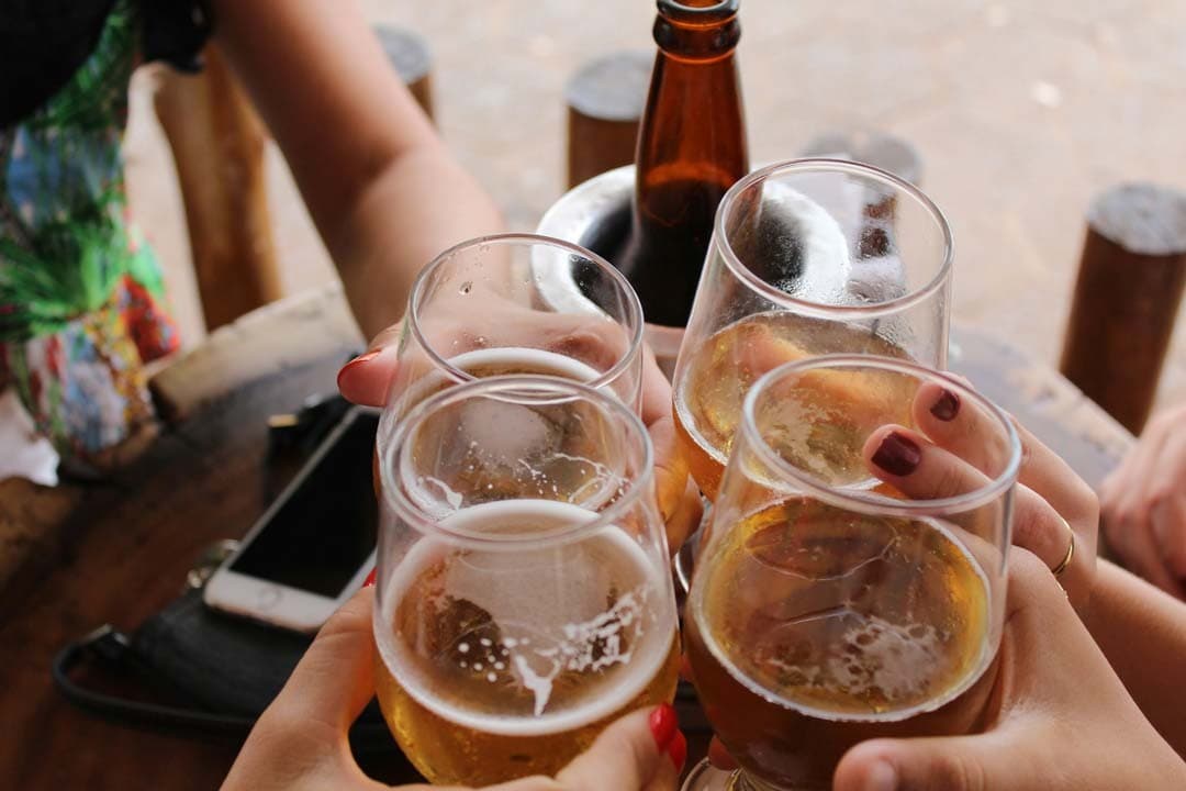 Groupe d'amis trinquant en terrasse, instant convivial et chaleureux. L'univers Moody CBD célèbre les moments partagés et la bonne humeur